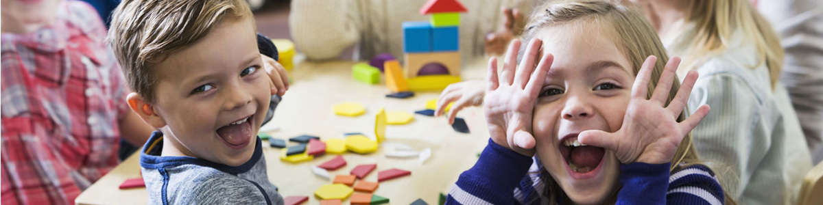 happy young children sitting at table