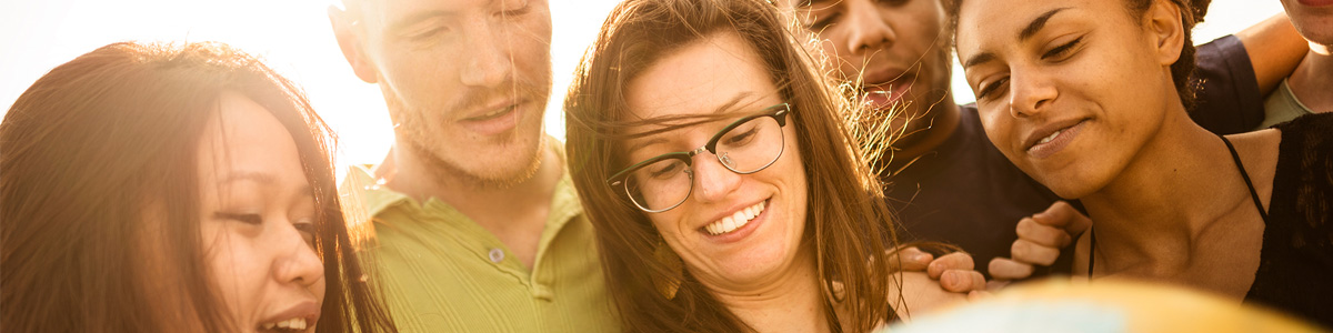 group of students looking at globe