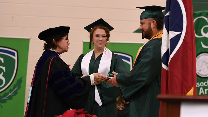 Faith Kennedy and Robert Austbrooks receives PLS medallion from Dr. Smith