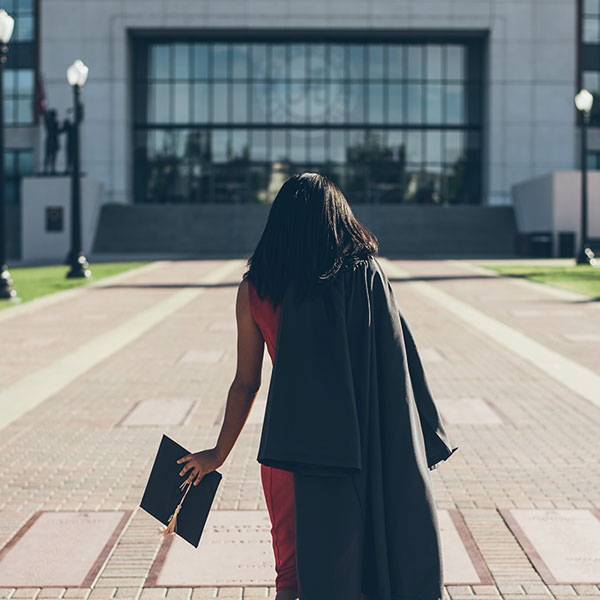 graduate walking towards building