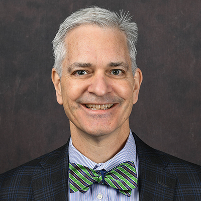 Profile photo of Aaron Beshears, a Director, in front of a professional backdrop.