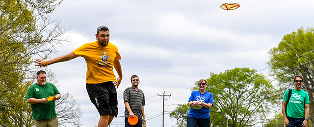 students playing disc golf