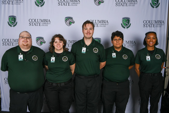 A photo show five people in front of a white background.