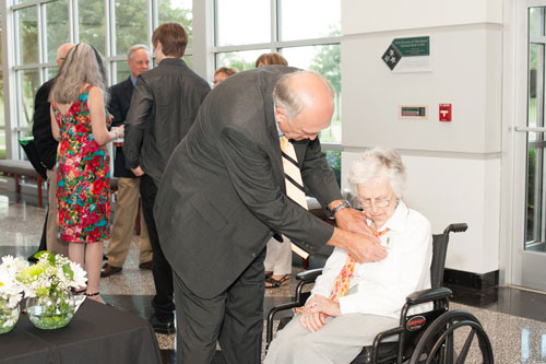 Man putting pin on woman in wheelchair