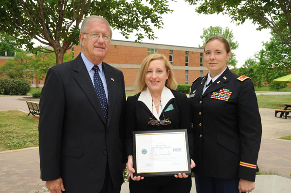 Two men and a women with award