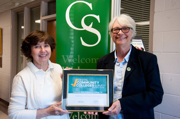 Two ladies holding an award