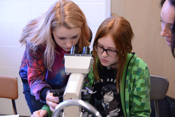 STEM attendees at microscope