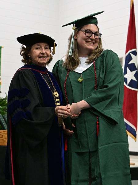 student shaking hands with president smith