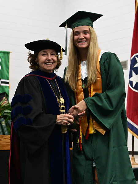 student shaking hands with president smith