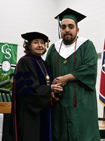 student shaking hands with president smith