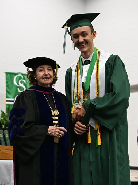 student shaking hands with president smith