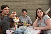 Three students smilling over a sundae