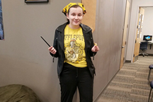 Student dressed in black and yellow with wand in hand