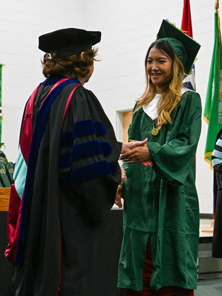 student shaking hands with president smith