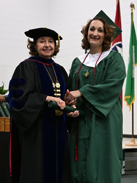 student shaking hands with president smith